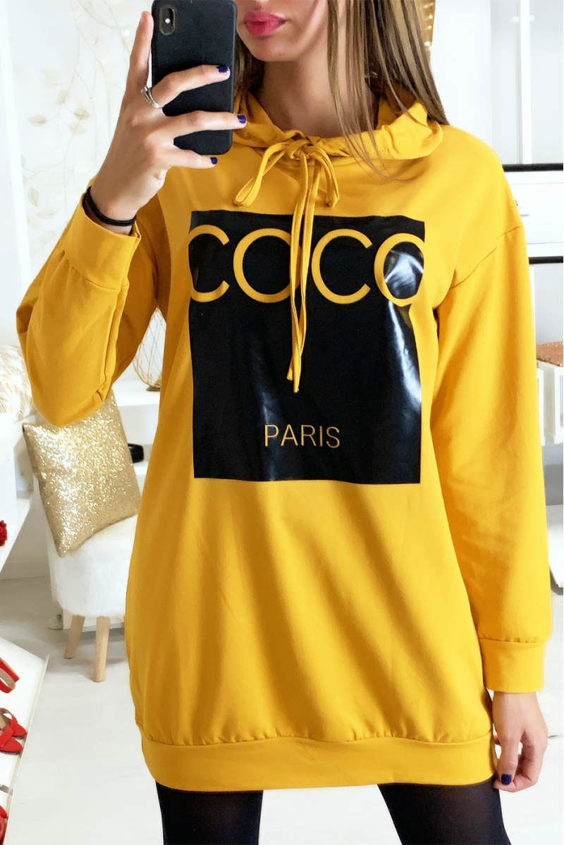 Mosterd hoodie met kokosnoot schrijven op glanzende achtergrond Mosterd hoodie met kokosnoot schrijven op glanzende achtergrond