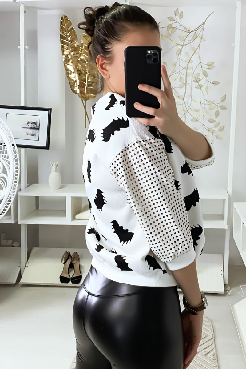 Pull blanc à motif chauve-souris et manches à trou quadrillé. Pull blanc à motif chauve-souris et manches à trou quadrillé.