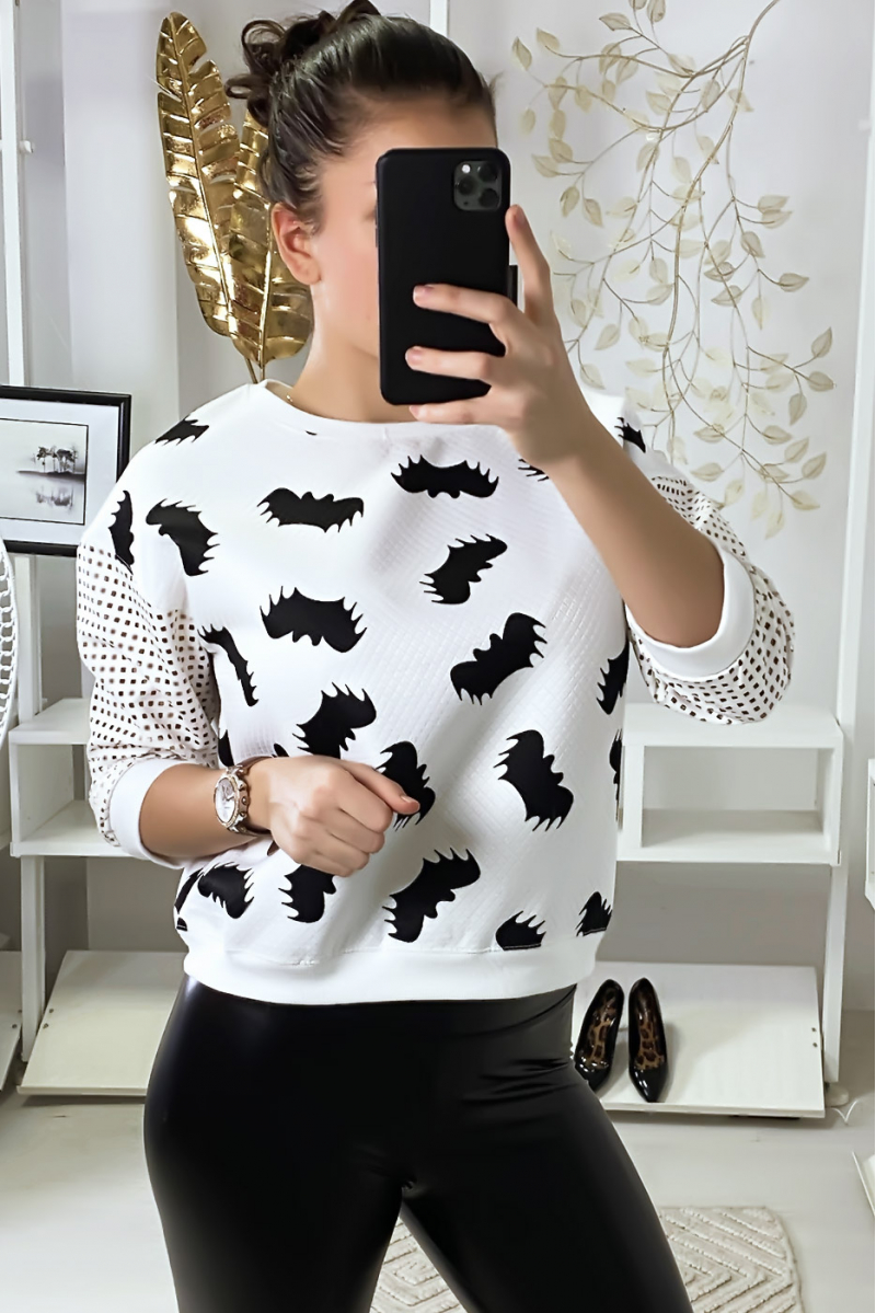 Pull blanc à motif chauve-souris et manches à trou quadrillé. Pull blanc à motif chauve-souris et manches à trou quadrillé.