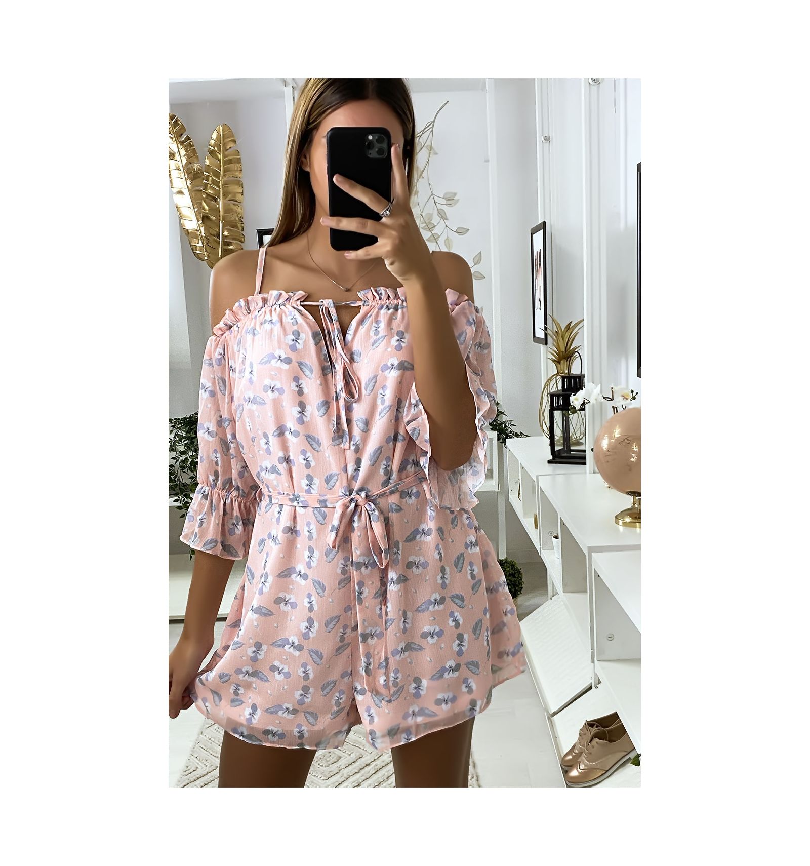 Dames jumpsuit met roze ruche en bloemmotief.