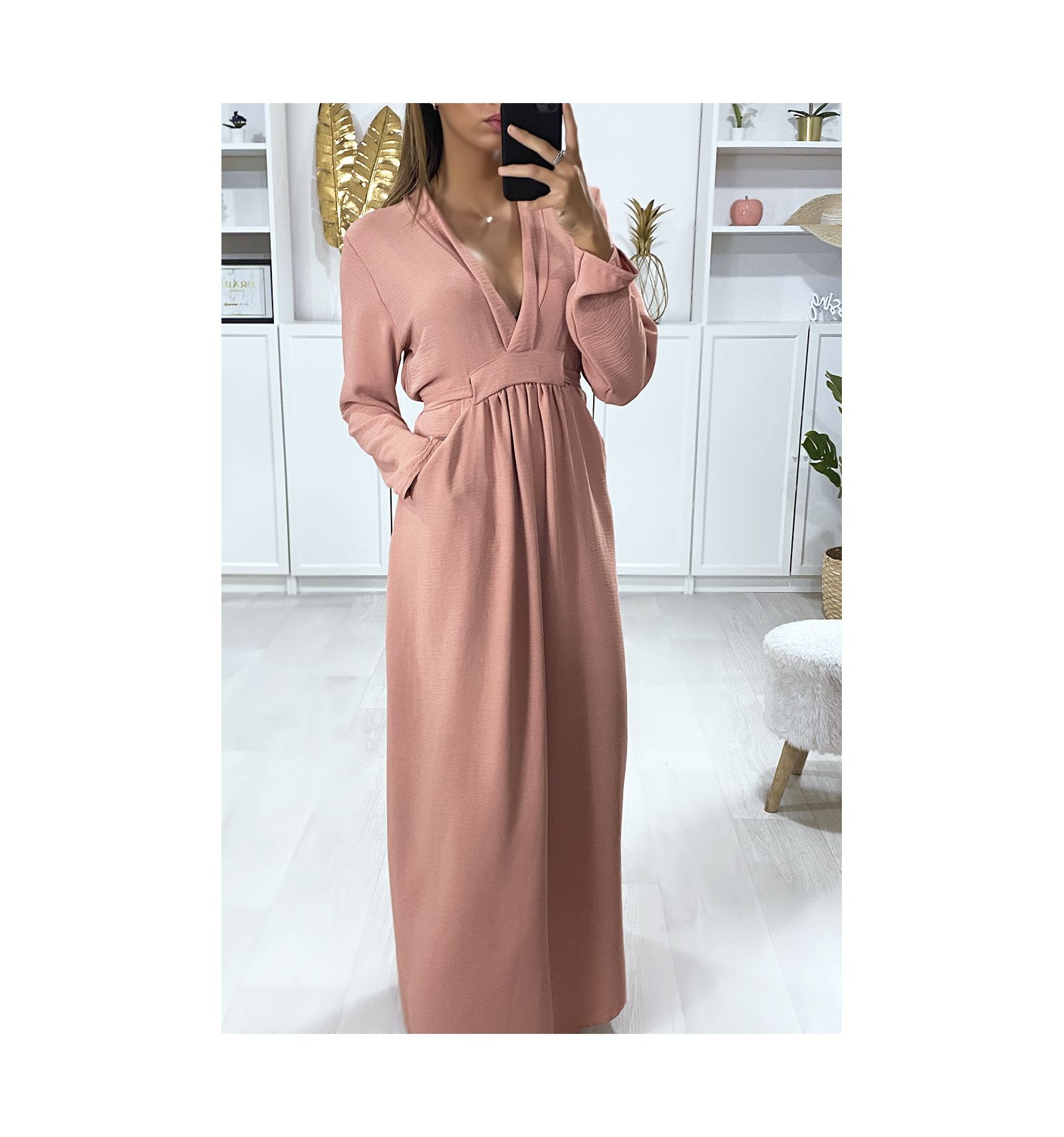 Longue robe rose ample en vol V avec ceinture et poches.